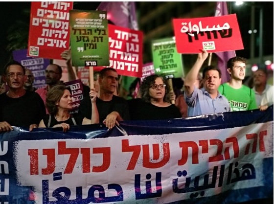 Foto 1 - Parlamentares participam de protesto em Israel contra nova lei - Na faixa - Este é o nosso lar - Foto - Al Ittihad-PC de Israel